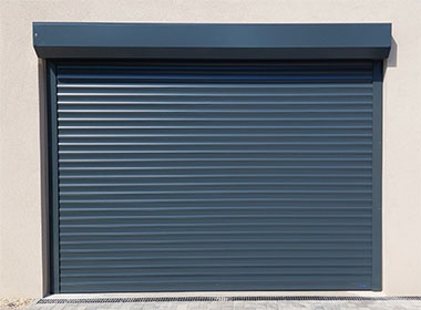 Tmavě šedá rolovací garážová vrata vhodná pro průmyslové i soukromé použití, nabízená firmou VRATA-L&V s důrazem na bezpečnost a styl.
